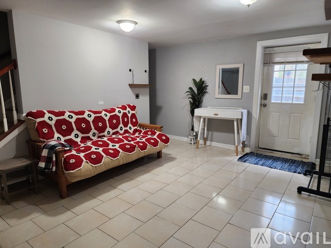 A living room with a couch and a desk.