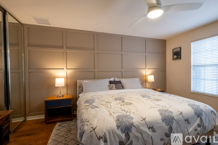 A bedroom with a large bed and a ceiling fan.