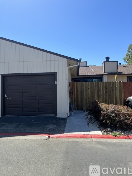 A house with a garage door and a red line on the sidewalk.