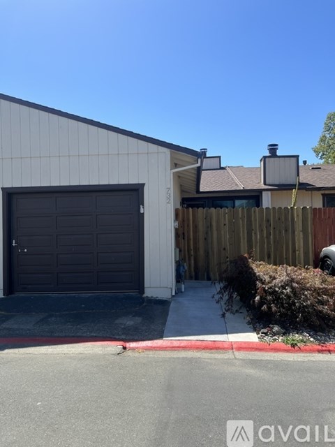 A house with a garage door and a red line on the sidewalk.