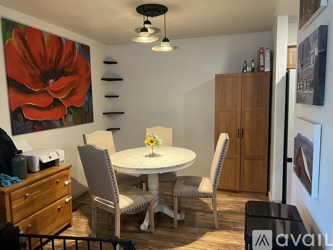 A dining room with a white table and chairs.