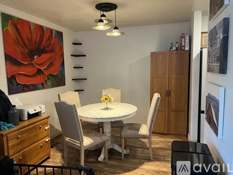 A dining room with a white table and chairs.