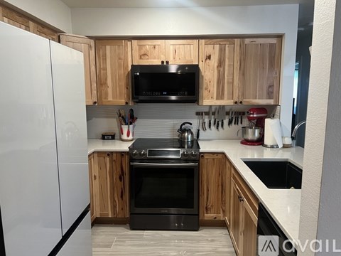 A kitchen with wooden cabinets and black appliances.
