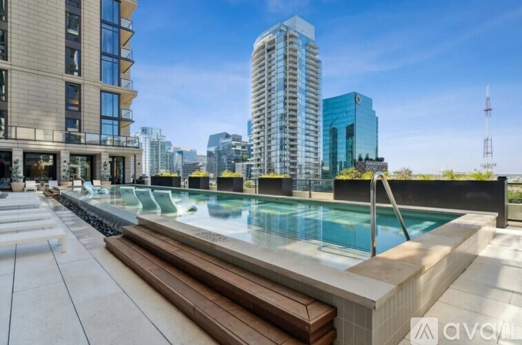 A modern pool area with a bench and a view of the city.