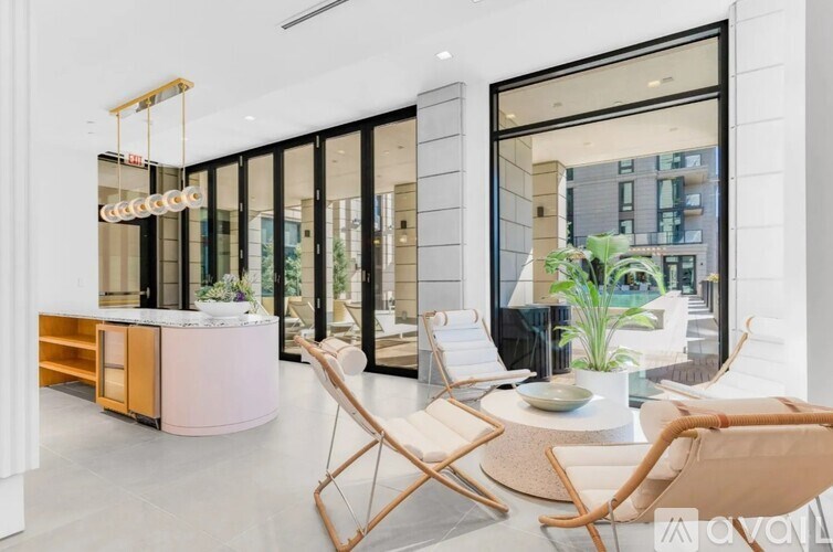 A modern living room with a white sofa and wooden chairs.