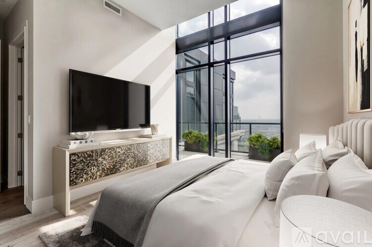 A modern bedroom with a large bed and a flat screen TV.