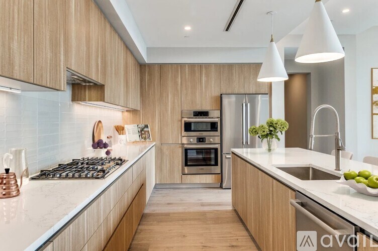 A modern kitchen with wooden cabinets and stainless steel appliances.