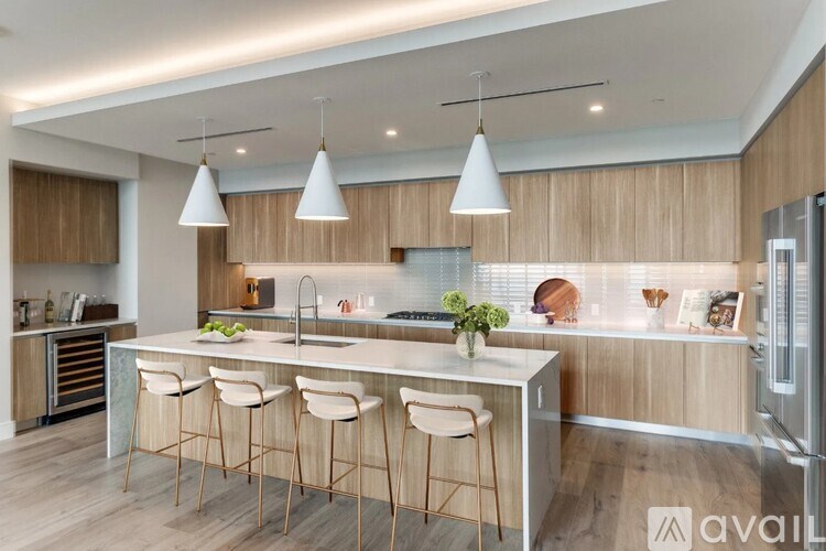 A modern kitchen with a bar area and stools.