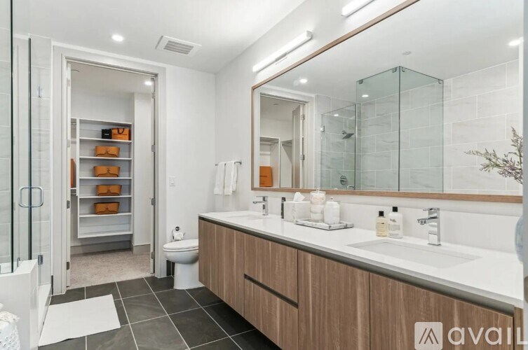 A bathroom with a white counter top and a wooden cabinet.