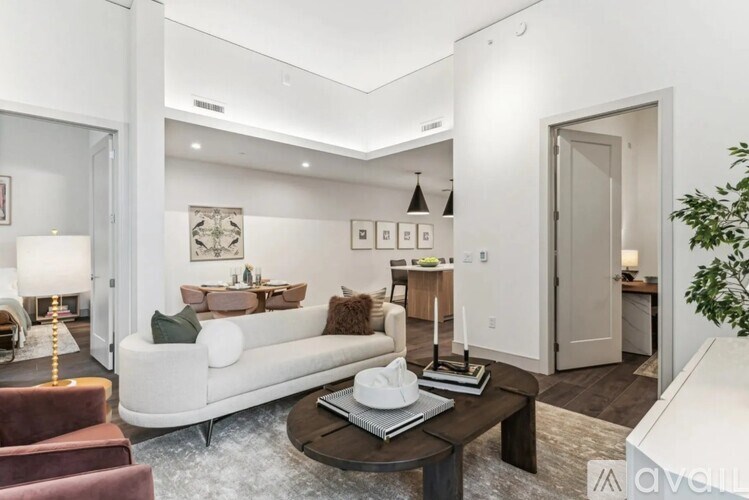 A living room with a white couch, a brown armchair, a coffee table, and a lamp.