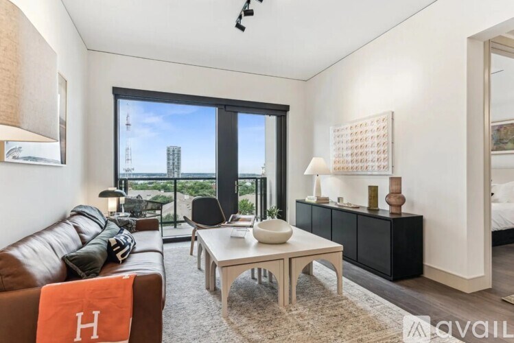 A living room with a brown leather couch and a white coffee table.