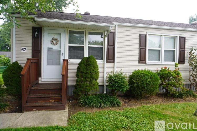 A house numbered 677 with a front yard and a wreath on the door.