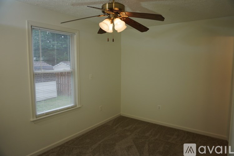 A room with a ceiling fan and a window with blinds.