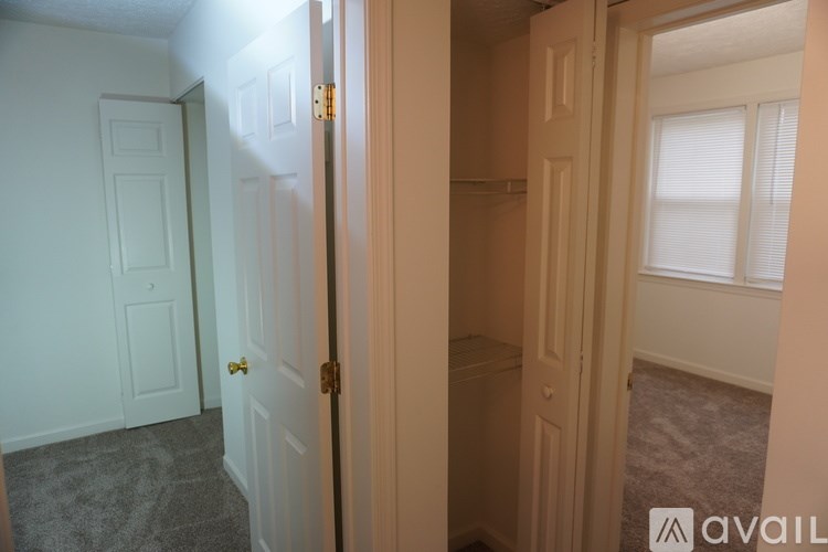 A hallway with a door on the left and a window on the right.