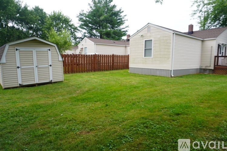 A backyard with a shed and a house.