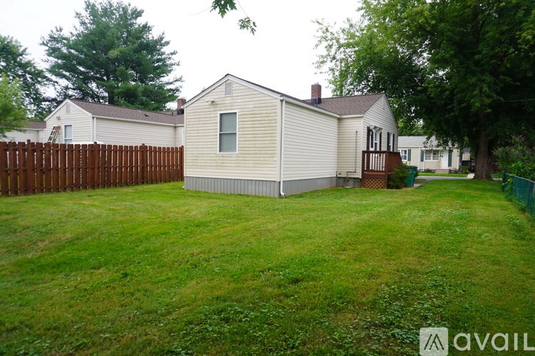A backyard with a fence and a house.