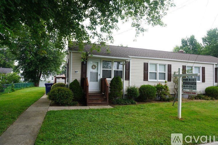 A house with a "For Rent" sign in front of it.
