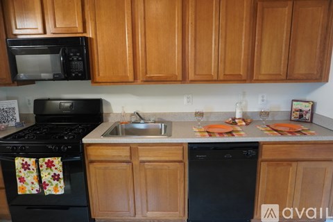 A kitchen with wooden cabinets and black appliances.