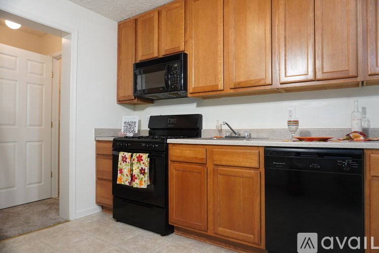 A kitchen with wooden cabinets and black appliances.