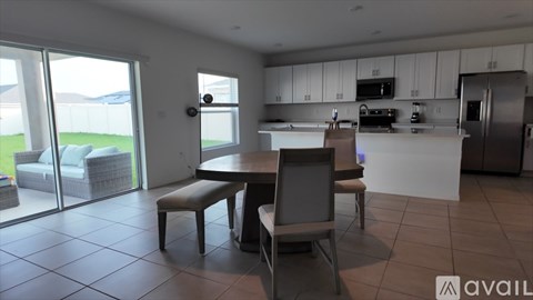 A kitchen with a table and chairs in the middle of the room.
