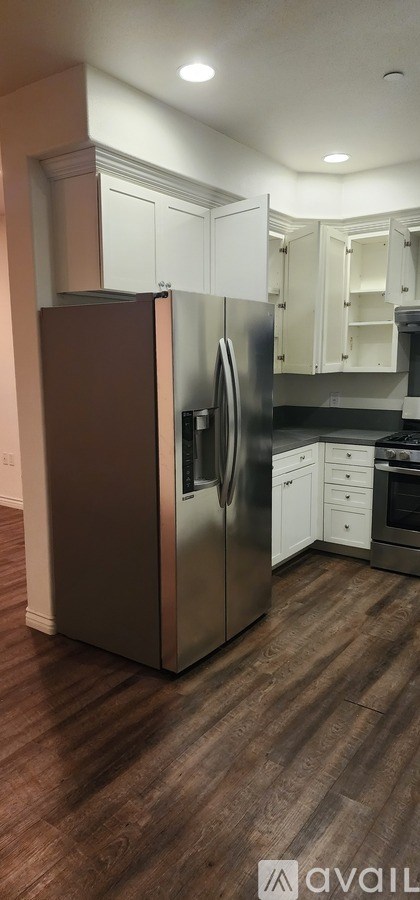 A kitchen with a brown fridge and white cabinets.