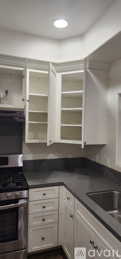 A kitchen with white cabinets and a stainless steel oven.