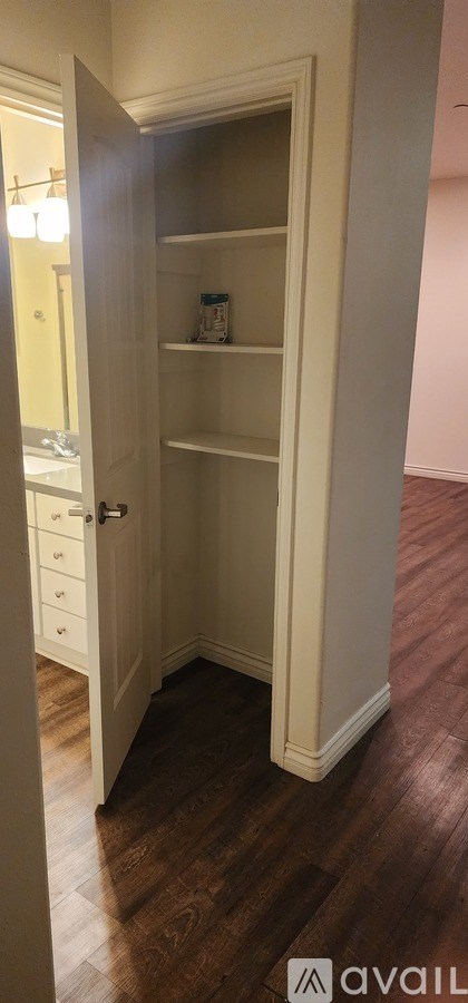 A white door is open to a room with a white shelf.