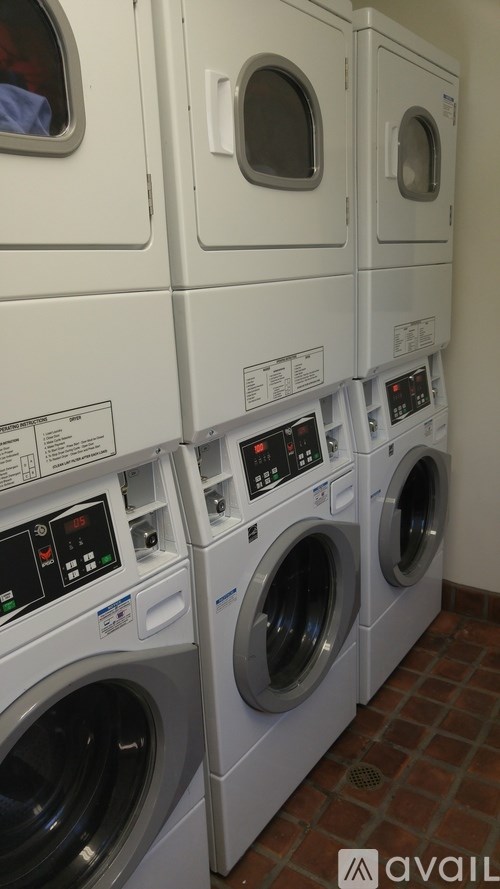 A row of white front load washing machines in a laundromat.