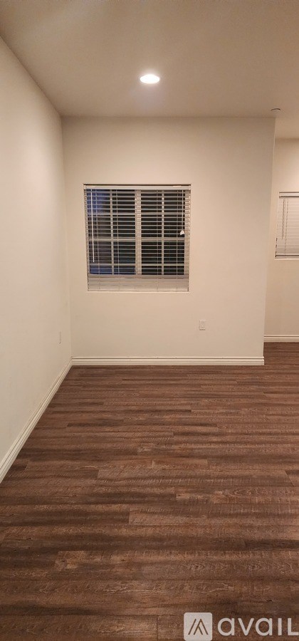 A room with a window and wooden flooring.
