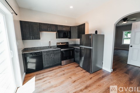 A kitchen with black cabinets and stainless steel appliances.
