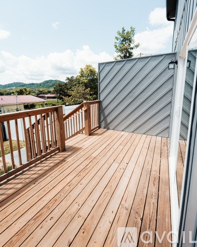 A wooden deck with a metal roof and a view of the mountains.