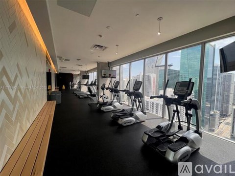 A gym with exercise bikes and a view of the city.