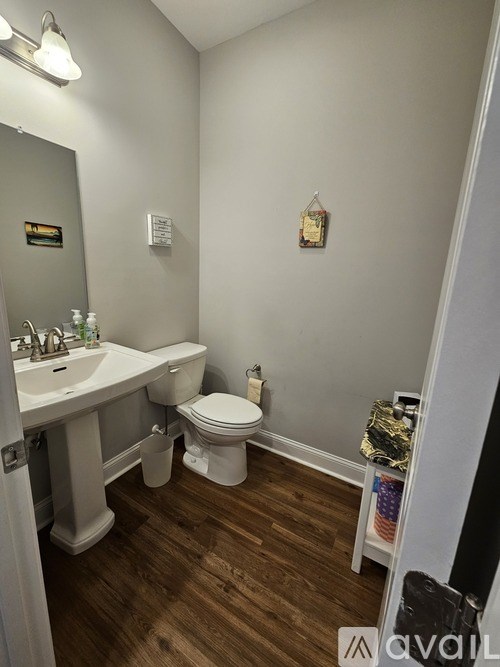 A bathroom with a toilet, sink, and mirror.