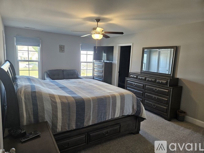 A bedroom with a bed, dresser, and mirror.