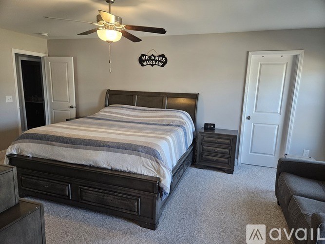 A bedroom with a large bed and a ceiling fan.