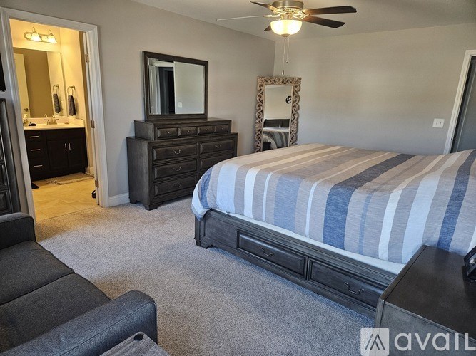 A bedroom with a bed, dresser, and mirror.