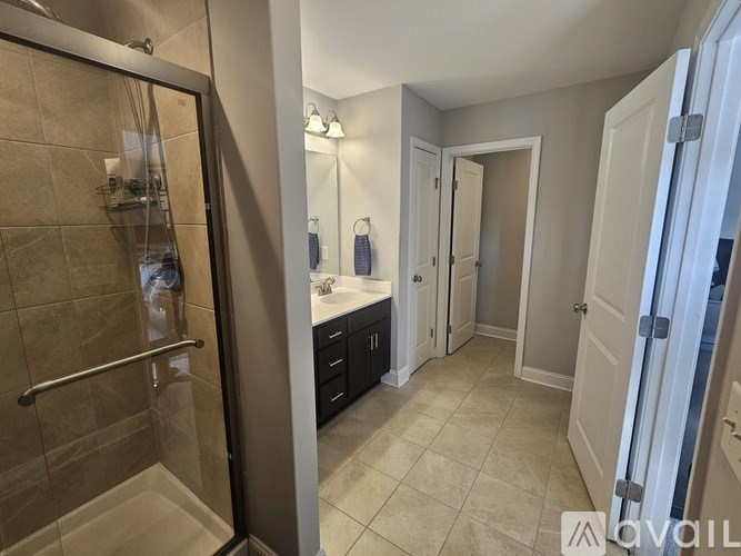 A bathroom with a walk-in shower and a sink vanity.