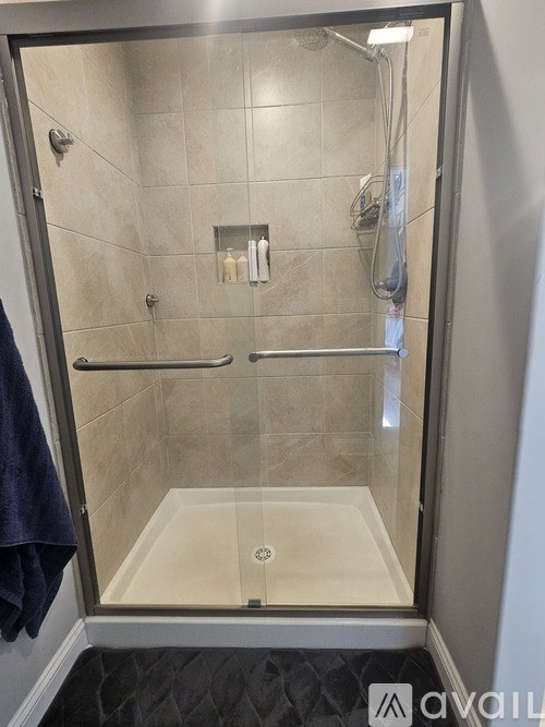 A bathroom with a glass shower door and a blue towel hanging on the side.