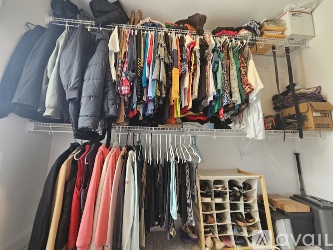 Clothes hanging on a rack in a closet.