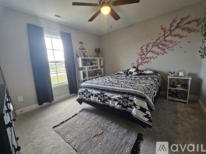 A bedroom with a large bed and a ceiling fan.