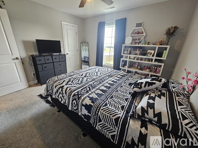A bedroom with a patterned bedspread and a black and white bed.