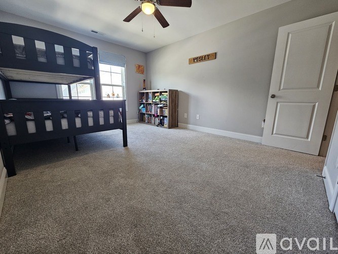 A room with a bunk bed and a bookshelf.