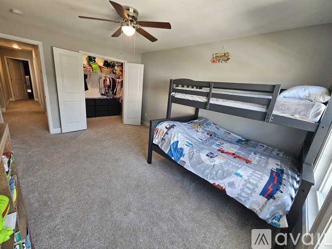 A bedroom with a bunk bed and a ceiling fan.