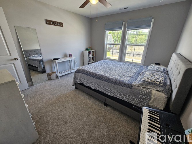 A bedroom with a large bed and a piano.