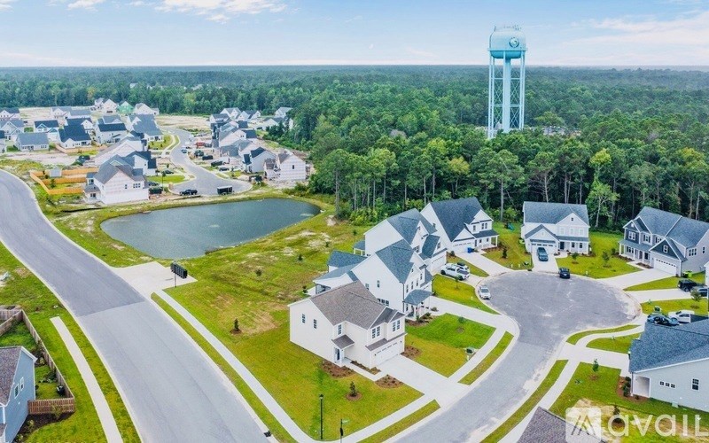 A water tower stands tall in the distance behind a small town.