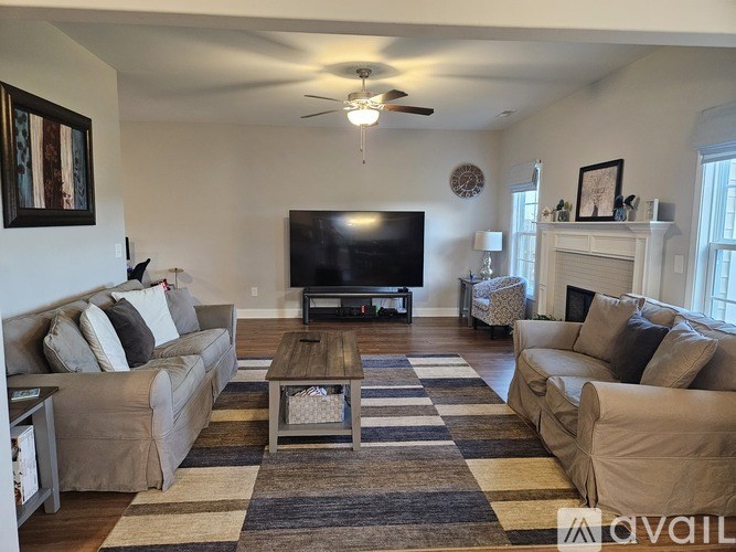 A living room with a television and two couches.