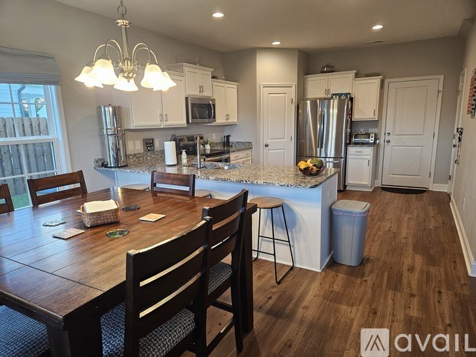 A kitchen with a dining table and chairs.