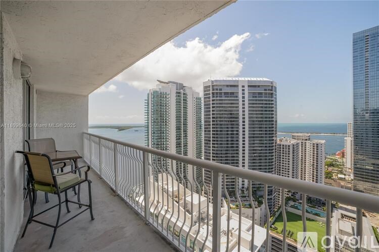 A balcony with a chair and a view of the city.