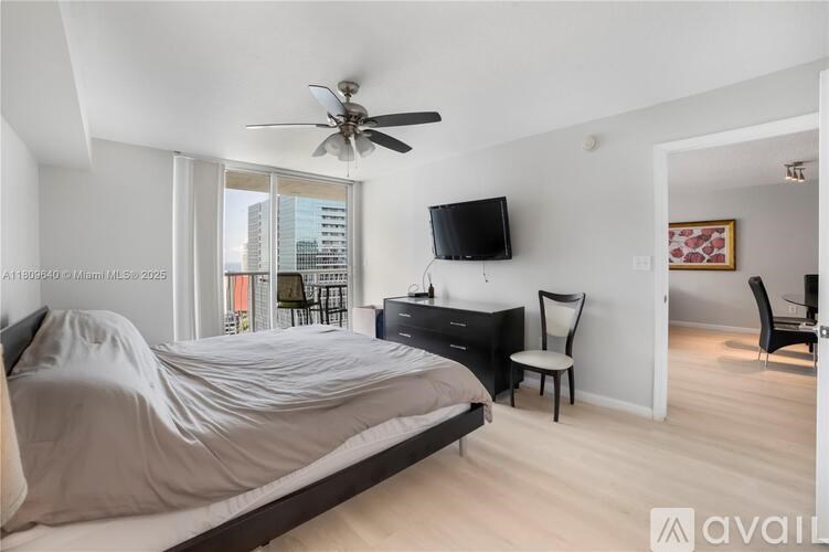 A bedroom with a bed, chair, and television.
