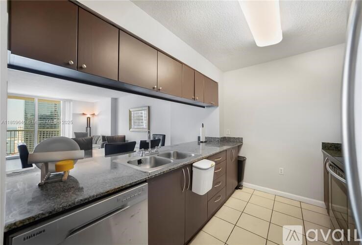 A kitchen with brown cabinets and a black countertop.